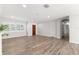 Open-concept living room with wood-look flooring and modern lighting fixtures, a serene and inviting space at 3945 Versailles Dr, Tampa, FL 33634