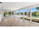 The bright and airy sunroom has waterfront views through large windows and lovely hardwood floors at 3945 Versailles Dr, Tampa, FL 33634