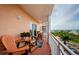 Balcony with chairs and a small table overlooking the trees and neighborhood at 4516 Seagull Dr # 615, New Port Richey, FL 34652
