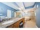 This well-lit bathroom has a soaking tub, glass shower, granite counters, and wood cabinets at 4516 Seagull Dr # 615, New Port Richey, FL 34652