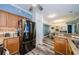 Galley kitchen with granite counters, stainless steel refrigerator, wood cabinets, and views of the dining area at 4516 Seagull Dr # 615, New Port Richey, FL 34652