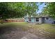 Backyard view of the home showing the new windows, teal door, patio and spacious yard at 5115 32Nd N Ave, St Petersburg, FL 33710