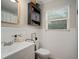 Well-lit bathroom featuring modern vanity, toilet, and classic white paneling at 5115 32Nd N Ave, St Petersburg, FL 33710