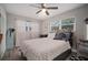 Comfortable bedroom with a ceiling fan, large windows, and a bed with a floral pattern at 5115 32Nd N Ave, St Petersburg, FL 33710