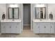 Bright bathroom boasts double vanity sinks with gray framed mirrors and neutral color palette at 5313 Windy Grove Dr, Wimauma, FL 33598