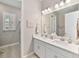 Bright bathroom featuring a double sink vanity, a shower behind a glass door, and coastal decor at 5313 Windy Grove Dr, Wimauma, FL 33598