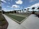 Community bocce ball court featuring three courts, palm trees, and benches at 5313 Windy Grove Dr, Wimauma, FL 33598