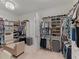 Large walk-in closet with extensive shelving, cabinets, and a comfortable seating area at 5313 Windy Grove Dr, Wimauma, FL 33598