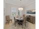 Elegant dining room with chandelier, wood table and chairs, and accent wall art at 5313 Windy Grove Dr, Wimauma, FL 33598