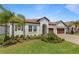 Beautiful single-story home with a well-manicured lawn, lush landscaping, and a tile roof at 5313 Windy Grove Dr, Wimauma, FL 33598