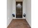Inviting front entrance featuring a dark wood door, brick floor, and decorative potted plants at 5313 Windy Grove Dr, Wimauma, FL 33598