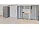 Garage featuring ample storage space with gray cabinets and workbench, plus sliding door at 5313 Windy Grove Dr, Wimauma, FL 33598