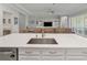 Open-concept kitchen featuring a large island with a sink, white cabinets, and stainless steel appliances at 5313 Windy Grove Dr, Wimauma, FL 33598