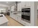 Modern kitchen featuring white cabinets, stainless steel appliances, and a light countertop at 5313 Windy Grove Dr, Wimauma, FL 33598