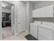 Functional laundry room with washer, dryer, storage cabinets, and access to a walk-in closet at 5313 Windy Grove Dr, Wimauma, FL 33598