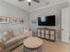 Neutral living room with sofa, side table, and entertainment center at 5313 Windy Grove Dr, Wimauma, FL 33598