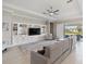 Open living room with custom built-ins, plush carpet and view of the outdoor patio at 5313 Windy Grove Dr, Wimauma, FL 33598