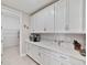 Bright pantry with white cabinets, quartz countertop, and ample storage with wire shelving at 5313 Windy Grove Dr, Wimauma, FL 33598