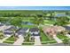 Stunning aerial view of homes overlooking a lush golf course with scenic water features and verdant trees at 5403 Avenal Dr, Lutz, FL 33558