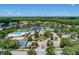 Community aerial view showcasing lush landscaping, a pool, tennis courts, and well-maintained homes at 5403 Avenal Dr, Lutz, FL 33558