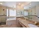 Luxurious bathroom featuring a jacuzzi tub, walk-in shower, and granite countertops at 5403 Avenal Dr, Lutz, FL 33558