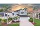 Beautiful two-story home featuring a well-manicured lawn, two-car garage, and elegant landscaping including mature palm trees at 5403 Avenal Dr, Lutz, FL 33558