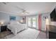 Bright main bedroom with a ceiling fan, French doors, and plush carpeting at 5403 Avenal Dr, Lutz, FL 33558