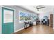 Bright home office featuring wood floors, a ceiling fan, and a desk overlooking a serene water view at 613 Fort Duquesna Dr, Sun City Center, FL 33573
