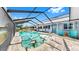 Beautiful screened-in pool area with bright blue chairs and pavers at 613 Fort Duquesna Dr, Sun City Center, FL 33573