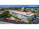 Aerial view of a building with parking, trees and a glimpse of the Gulf of Mexico in the background at 6161 Gulf Winds Dr # 338, St Pete Beach, FL 33706