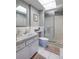 Bright bathroom featuring a white vanity with marble countertop, a toilet, and a glass-enclosed shower at 6161 Gulf Winds Dr # 338, St Pete Beach, FL 33706