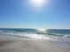 Beautiful ocean beach with waves gently crashing on the shore under a bright, sunny sky at 6161 Gulf Winds Dr # 338, St Pete Beach, FL 33706