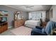 Comfortable bedroom with a large window, wood dresser with mirror, a comfy chair, and neutral decor at 6161 Gulf Winds Dr # 338, St Pete Beach, FL 33706