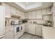 Well-lit kitchen featuring white appliances and cabinetry, complemented by light wood-look flooring and ample countertop space at 6161 Gulf Winds Dr # 338, St Pete Beach, FL 33706