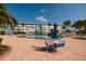 Community pool with surrounding patio area, seating, lush tropical landscaping, and nearby condo building at 6161 Gulf Winds Dr # 338, St Pete Beach, FL 33706