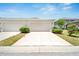 Exterior shot of a two-car garage with a well-maintained driveway and mature landscaping at 6325 Shore Vista Pl, Apollo Beach, FL 33572