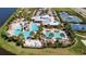 Community pool area with water slides, lounge chairs, and a clubhouse surrounded by palm trees at 6325 Shore Vista Pl, Apollo Beach, FL 33572