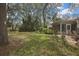 Lush backyard with grass, mature trees, and landscaping, creating a private outdoor oasis at 6375 Ocean Pines Ln, Spring Hill, FL 34606