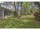 Beautiful yard with mature trees, landscaping, and a screened porch, perfect for relaxation and outdoor enjoyment at 6375 Ocean Pines Ln, Spring Hill, FL 34606