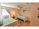 Neutral bedroom with two twin beds, decorated with beach-themed pillows and colorful floral area rug at 6416 Cobble Bliss St, Zephyrhills, FL 33541
