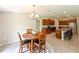 Open floorplan dining room features wood table, seating for four, and island seating at kitchen counter at 6416 Cobble Bliss St, Zephyrhills, FL 33541