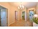 Inviting hallway with tile flooring, decorative lighting, and neutral wall colors at 6416 Cobble Bliss St, Zephyrhills, FL 33541