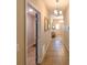 Long hallway featuring neutral paint, tiled floors, decorative lighting, and doorways to bedrooms at 6416 Cobble Bliss St, Zephyrhills, FL 33541