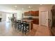 Spacious kitchen featuring an island with bar stools, granite countertops, and stainless steel appliances at 6416 Cobble Bliss St, Zephyrhills, FL 33541