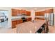 Open kitchen featuring an island with bar seating, granite countertops, and stainless steel appliances at 6416 Cobble Bliss St, Zephyrhills, FL 33541