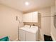 Functional laundry room with side-by-side washer and dryer and overhead cabinets at 6416 Cobble Bliss St, Zephyrhills, FL 33541