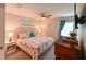 Comfortable bedroom features a ceiling fan, a queen bed, and bright turquoise curtains at 6416 Cobble Bliss St, Zephyrhills, FL 33541