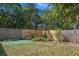 Fenced backyard with mature trees, green grass, and a small landscaped area perfect for gardening at 6936 77Th N Ter, Pinellas Park, FL 33781