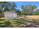Exterior of a detached garage with a well-kept lawn, surrounded by a wooden fence at 6936 77Th N Ter, Pinellas Park, FL 33781