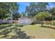 View of a detached garage featuring a lush green lawn and sturdy wooden fencing at 6936 77Th N Ter, Pinellas Park, FL 33781